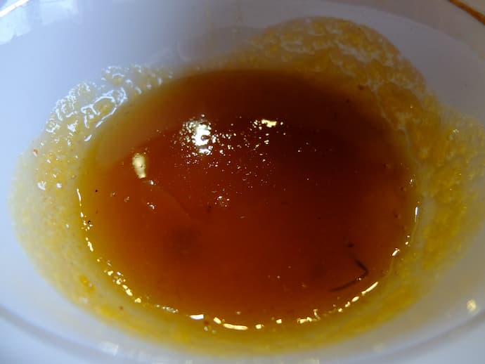 Варенье или желе из плодов айвы японской хеномелес — янтарно-коричневое, жидкое, в белой миске © blumgarden.ru