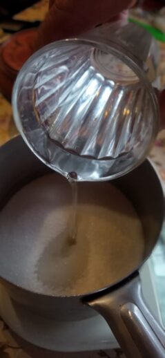 Добавление воды в сотейник с сахаром для приготовления сиропа для цукатов из айвы © blumgarden.ru